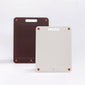Two bykurahome cutting boards, one brown and one beige, with visible brand logo on a white background.